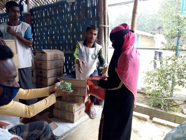 A woman receives soap distributed by an NGO