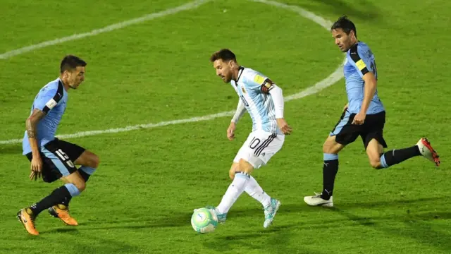 Lionel Messi entre dos uruguayos