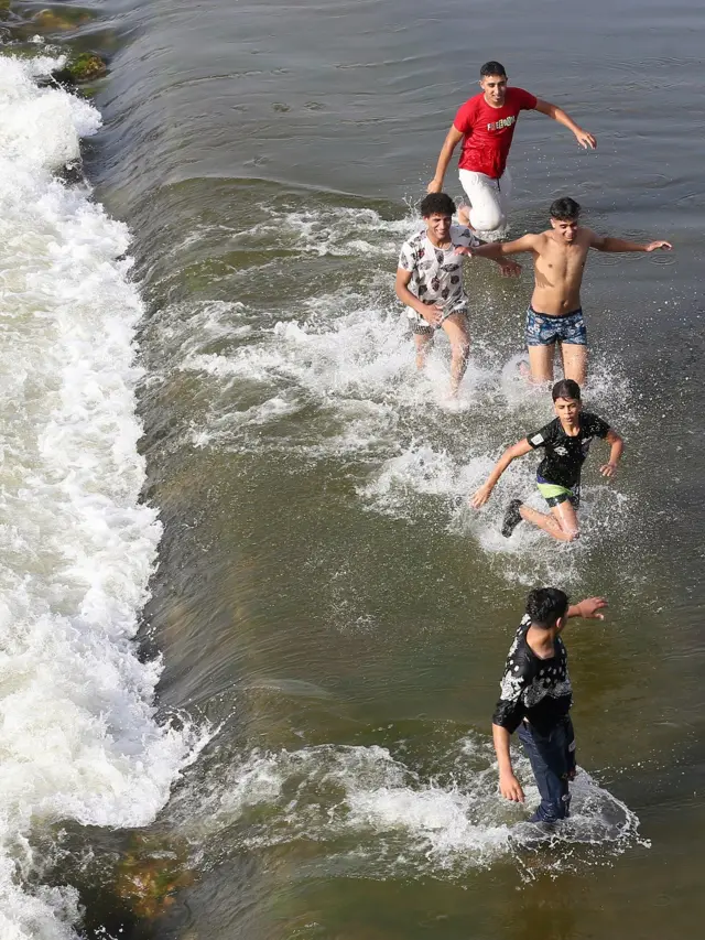 People swim in the Nile river during hot weather in the Qanater neighbourhood on the outskirts of Cairo, Egypt.