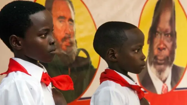 Two children are pictured in front of the portraits of the former Cuban president Fidel Castro and the former South Sudanese leader John Garang at the memorial service for the former Cuban president Fidel Castro organised by the Red Army and the Sudan People"s Liberation Movement (SPLM) in the SPLM House in Juba, South Sudan, on December 4, 2016.