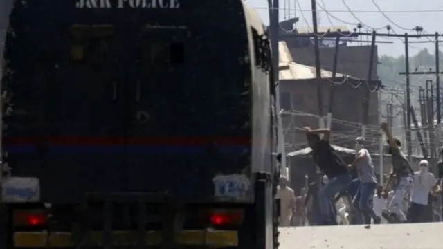 गाड़ी पर पथराव करते लोग