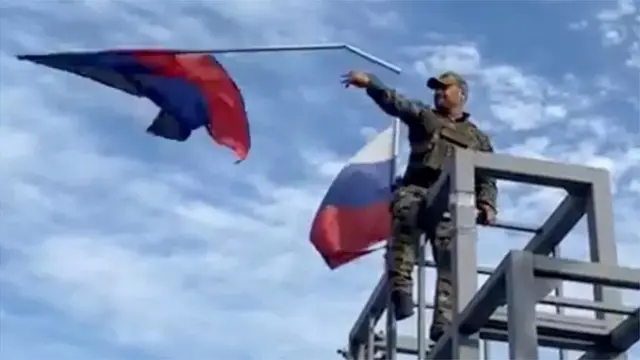 Украин жоокери Лимандагы администрациянын имаратынан Россиянын желегин алып ыргытууда