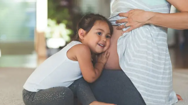 Criança ouve a barriga da mãe