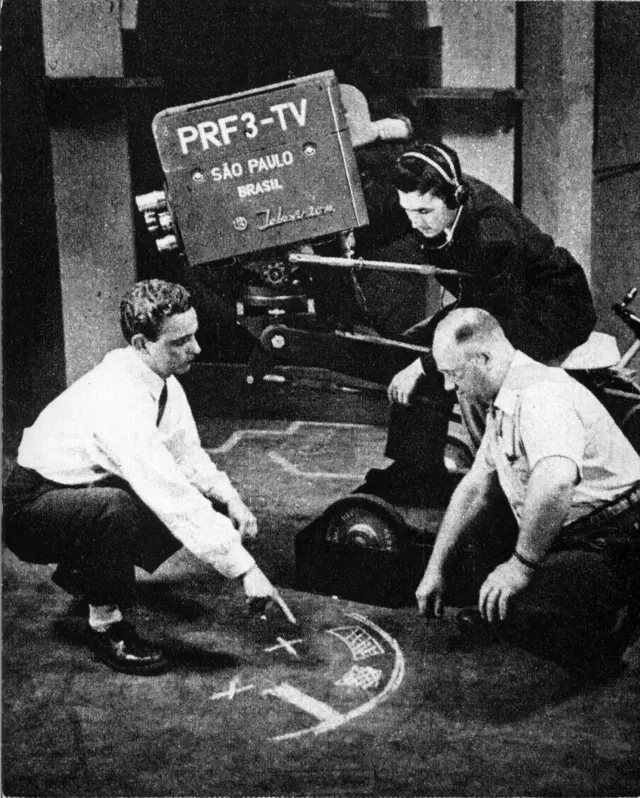 Horas antes da inauguração da Tupi, no dia 18 de setembro de 1950, o diretor de TV Luiz Gallon, o câmera Hélio Tozzi e técnico Waldemar Lejac se reúnem para estudar as últimas marcações de cena nos estúdios da PRF-3 TV Tupi-Difusora, mais conhecida como Tupi, no bairro do Sumaré, em São Paulo