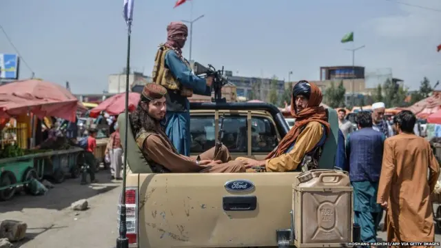 राजधानी काबुल के कोटे सांगी इलाक़े में बाज़ार में पिक-अप ट्रक पर घूमते तालिबान लड़ाके