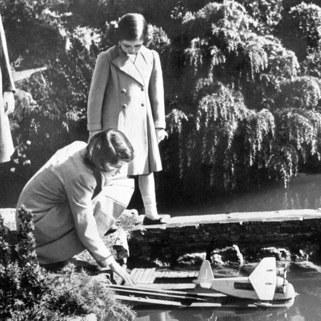 As princesas Elizabeth e Margaret lançando um modelo de hidroavião na vila modelo de Bekonscot em Beaconsfield, Buckinghamshire