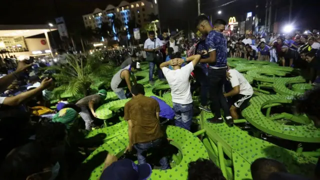 Gente alrededor de un árbol de la vida derrumbado.