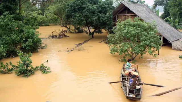 Người dân chèo thuyền trong nước lụt