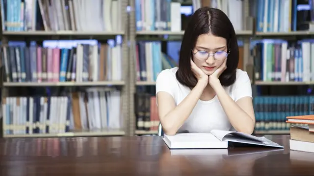 Una mujer leyendo en una biblioteca