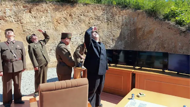 ภาพของสำนักข่าวกลางเกาหลีของเกาหลีเหนือ ซึ่งปล่อยออกมาเมื่อเดือนกรกฎาคม ปีนี้ คิม จอง อึนกำลังเงยหน้าดูจรวดฮวาซอง-14 ถูกยิงขึ้นสู่ท้องฟ้า