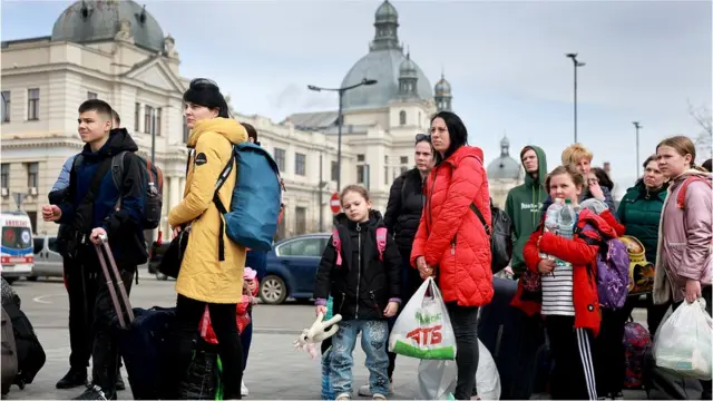 People fleeing the Russian military campaign in eastern Ukraine wait to board a bus that will take them to Poland on 9 April 2022 in Lviv, Ukraine