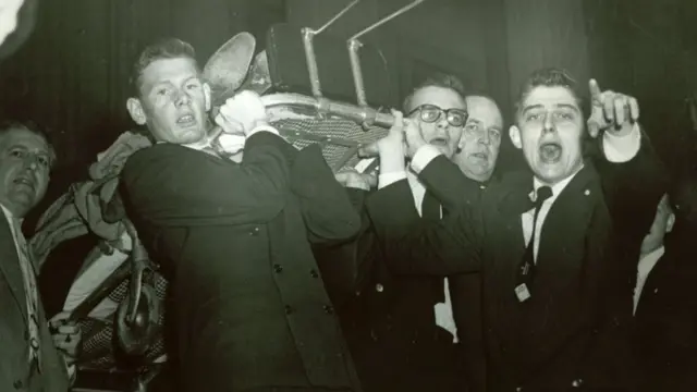 কংগ্রেস সদস্যরা স্ট্রেচারে করে একজন সহর্মীকে সরিয়ে নিচ্ছেন।