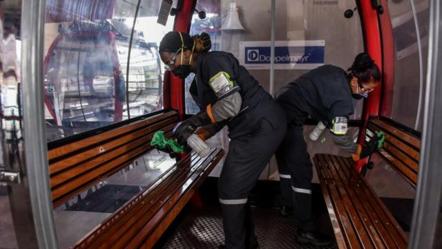 Mujeres limpian el interior del metrocable en Medellín