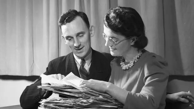 W. G. Cain (izq) y A. M. Johnson revisan la correspondencia de oyentes en América Latina