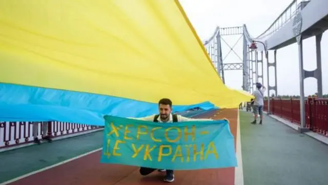 'খেরসন ইউক্রেনের' লেখা ব্যানার নিয়ে এক ইউক্রেনীয়