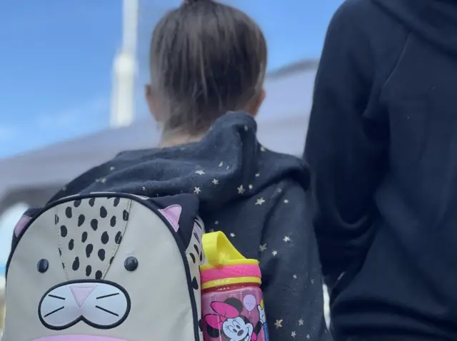 Niña ucraniana con mochila junto a su madre en el cruce fronterizo de San Ysidro el 15 de marzo de 2022.