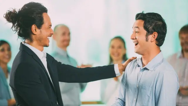 Compañero de trabajo felicita a un colega.
