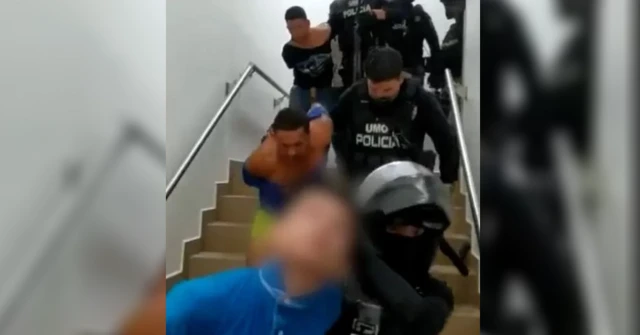 La policía conduce a unos hombres a la salida de un hospital tras su detención.