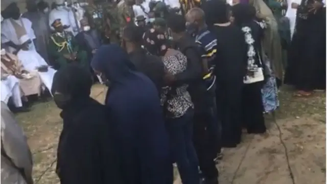 Diẹ lara ẹbi awọn oloogbe nibi eto isinku naa lasiko ti wọn n tẹwọ gba asia Naijiria