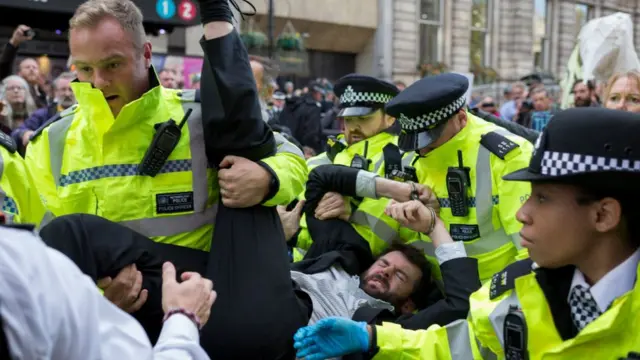 поліція виносить демонстранта