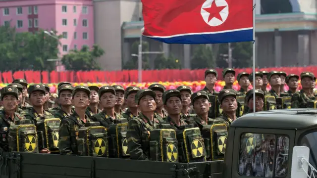 Prajurit Korea Utara membawa simbol nuklir dalam parade.