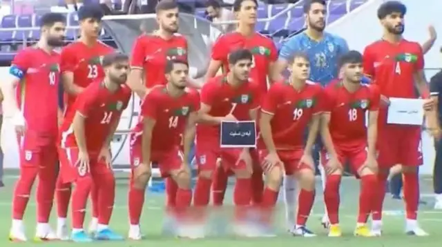 در تصویر دو تن از بازیکنان تیم ملی المپیک ایران در همدلی با کشته‌شدگان، بازماندگان و خانواده‌هایشان برگه‌هایی به دست گرفتند