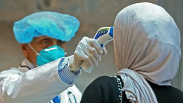موظفو وزارة الصحة الكويتية يفحصون موظفي مجمع الوزارات عند وصولهم إلى عملهم في مدينة الكويت