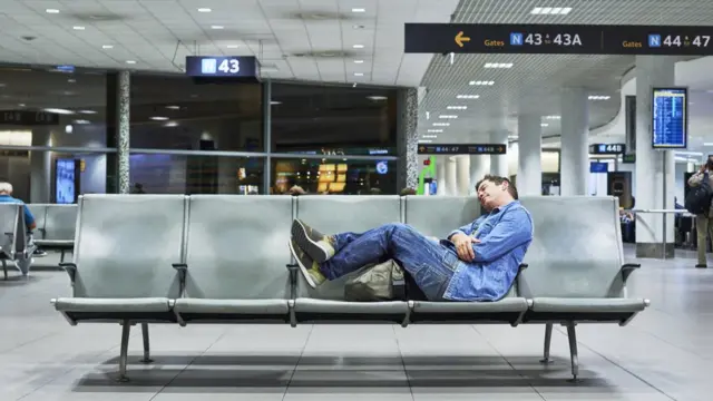 Homem dormindo no aeroporto