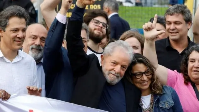 Lula cercadoestrela bet footballapoiadores faz gesto com os dedos imitando a letra L