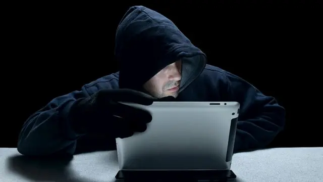 رجل يتعامل مع حاسوب في الظلام