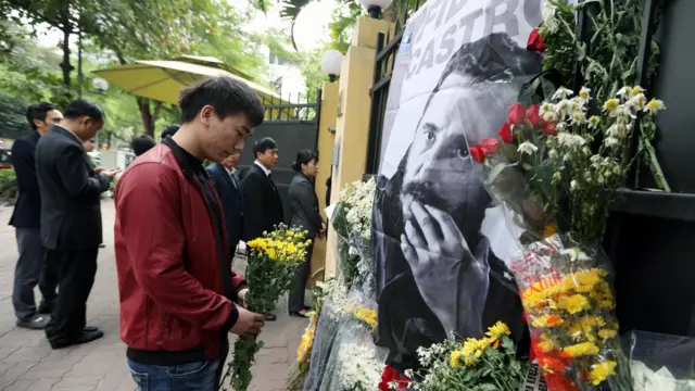 Một thanh niên đặt hoa viếng ông Fidel Castro trước cửa Đại sứ quán Cuba