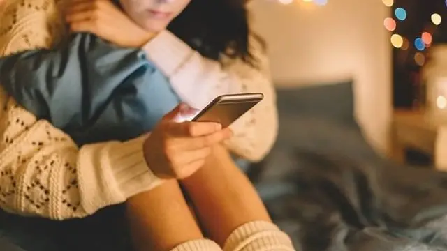 Мобил телефонини қараб ўтирган ўсмир қиз