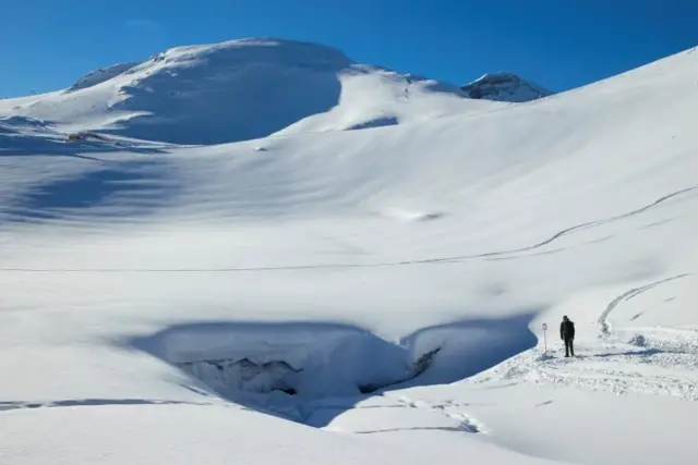 the entrance of the "Mill", a 20m long natural ice cave created by melted water accumulated during the summer and by a siphon effect leaves in the autumn giving way to an ice cathedral