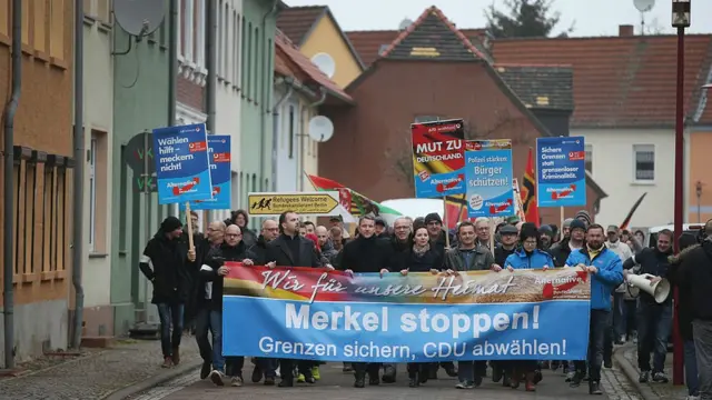 AfD protestocularının taşıdığı pankartta "Merkel'i durdurun, Sınırları güvenceye alın, CDU'yu bırakın!" yazıyor