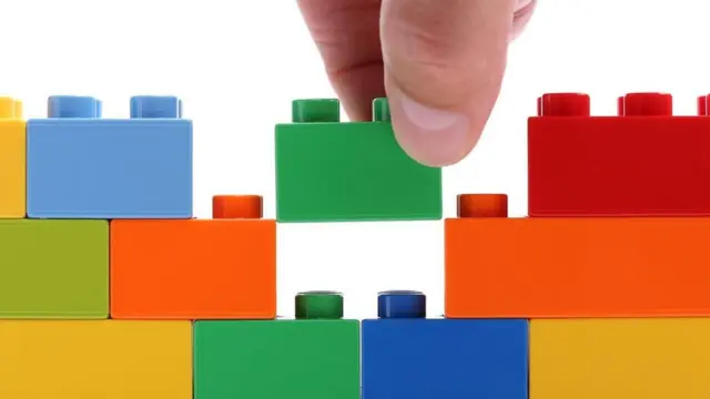 Una persona haciendo una construcción con piezas de Lego.