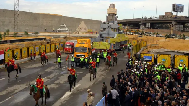 شاحنة تسحب عربتين كبيرتين بينهما إطار معدني صممت خصيصا لهذا الغرض