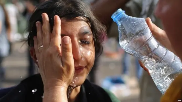 A migrant girl is overcome by pepper spray and tear gas on September 16, 2015 in Horgos, Serbia