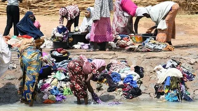 Mata suna wanke kayansu a rafi