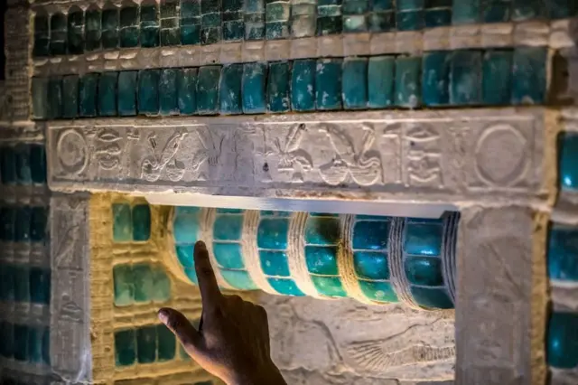 A man points at the hieroglyphs.