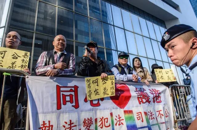 在庭外支持警方執法的團體手持"公義何在？"的標語牌示威。