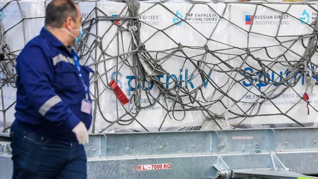 Aeroport işçisi Sputnik V vaksini fonunda