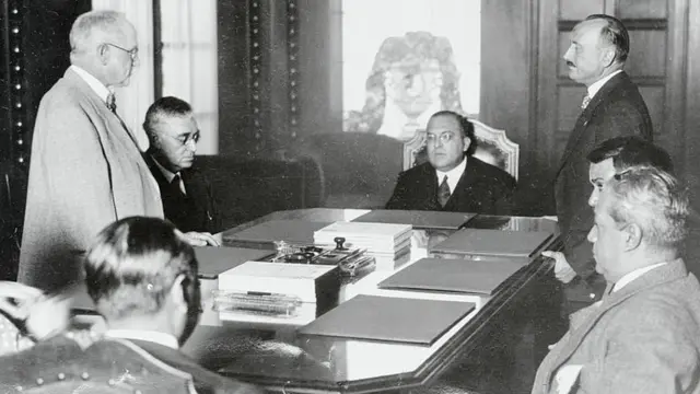 Genaro Estrada, sentado a la cabeza de la mesa