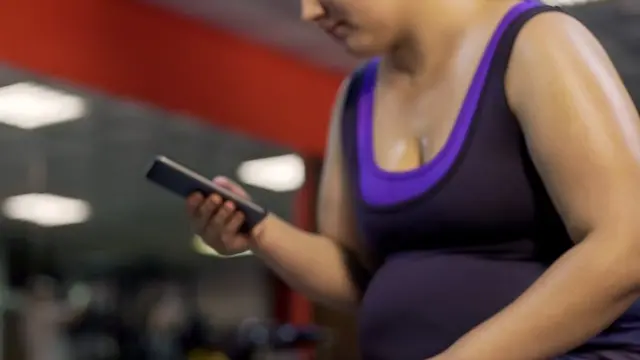Woman checking her phone in the gym