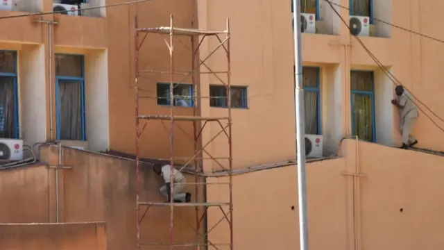 தாக்குதலுக்கு உள்ளான ராணுவத் தலைமையகத்தில் இருந்து தப்பித்து வெளியேறும் நபர்கள்.