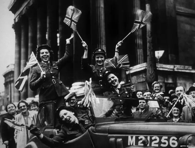 ਔਕਜ਼ੀਲਰੀ ਟੈਰੀਟੋਰੀਅਲ ਸਰਵਿਸ (ਏਟੀਐੱਸ) ਦੇ ਮੈਂਬਰ 8 ਮਈ 1945 ਨੂੰ ਲੰਡਨ ਵਿੱਚ VE ਦਿਵਸ ਦੇ ਜਸ਼ਨਾਂ ਦੌਰਾਨ ਟ੍ਰੈਫਲਗਰ ਸਕੁਆਇਰ ਵਿੱਚੋਂ ਲੰਘਦੇ ਹੋਏ।