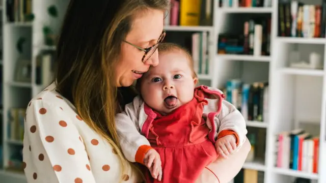 Pia being held by her mother, Ellen De Meyer