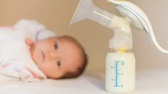 Un bebé y un biberón.