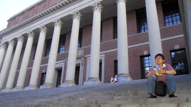 Students sit on the steps of a library at Harvard University