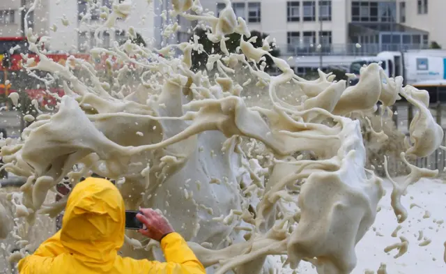 A man takes a picture of sea spray as storms hit Cape Town, South Africa, June 7, 2017.