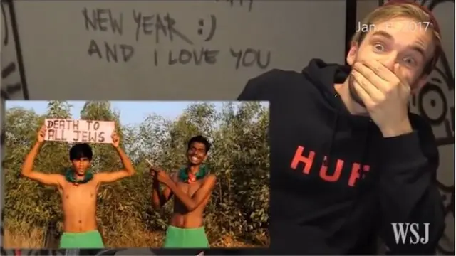 Captura de pantalla del canal de PewDiePie en el que dos indios levantan un mensaje antisemita "Muerte a todos los judíos".